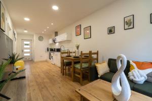 a living room and kitchen with a couch and a table at Cozy Urban 2BR with courtyard in Gloucestershire