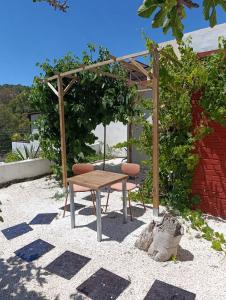 a wooden table and a bench in a garden at Relax Ferrandiz in Málaga