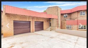 a brick building with two garage doors on it at Elikia in Pretoria