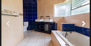 a bathroom with a tub and a sink and a toilet at Elikia in Pretoria
