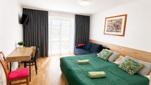 a living room with a green couch and a table at Ruciane Tarasy in Ruciane-Nida