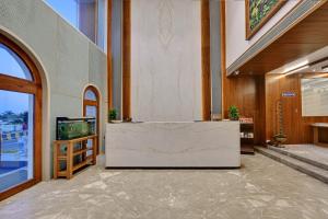 a lobby with a reception desk and a tv at Ira by Orchid Dwarka in Dwarka