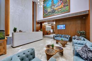 a lobby with two blue couches and a tv at Ira by Orchid Dwarka in Dwarka
