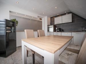 a kitchen with a wooden table in a kitchen at 216 große Ferienwohnung Schwalbennest in Wittmund +15 photos