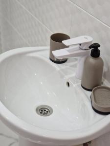 a white bathroom sink with a soap dispenser on it at Silver room 3 in Zatoka