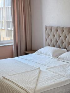 a bed with a white mattress and a window at Silver room 3 in Zatoka +6 photos