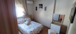 a small bedroom with a bed and a television at Appartement Résidence fermée avec piscine in Ben Slimane