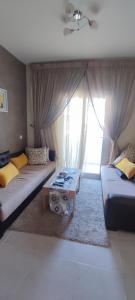 a living room with two couches and a window at Appartement Résidence fermée avec piscine in Ben Slimane