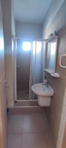 a bathroom with a shower and a sink and a mirror at Appartement Résidence fermée avec piscine in Ben Slimane