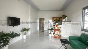 a living room with a green couch and a tv at sunnyhome 2 wide spaces in Ấp Ðại Tài (2)