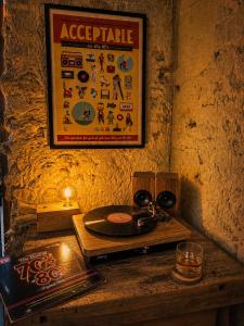 a table with a plate and a poster on a wall at Chez Cathy in Villandraut