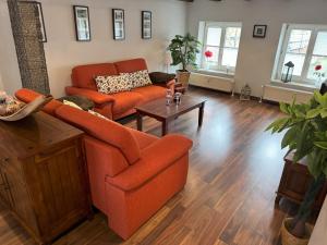 a living room with an orange couch and a table at Inseldomizil - Melina in Malchow