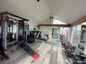 a gym with several tread machines in a room at Waterfront House in Finstown