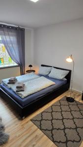 a bedroom with a bed with a rug and a lamp at Ferienwohnung Regina in Undenheim +5 photos