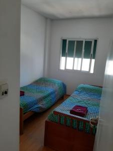 a room with two beds and a window at Parana in Rosario +1 photo