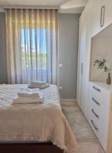 a bedroom with a bed with a dresser and a window at Novigrad Garden Apartment in Novigrad Istria +9 photos