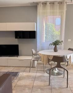 a living room with a table and a tv at Novigrad Garden Apartment in Novigrad Istria