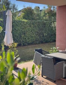 a patio with an umbrella and a table and chairs at Novigrad Garden Apartment in Novigrad Istria
