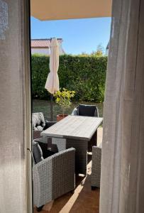 a patio with a table and chairs and an umbrella at Novigrad Garden Apartment in Novigrad Istria