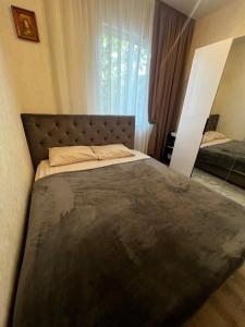 a bedroom with a large bed and a window at Anna in Rivne
