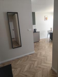 a room with a mirror and a wooden floor at Apartament Isabell in Busko-Zdrój