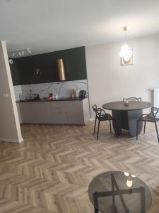 a living room with a table and a kitchen at Apartament Isabell in Busko-Zdrój