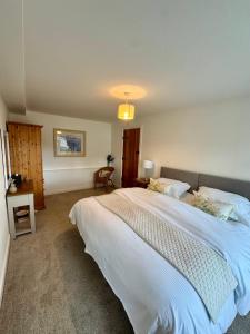 a bedroom with a large white bed in it at Castle View Cottage at Snape Castle Mews in Bedale