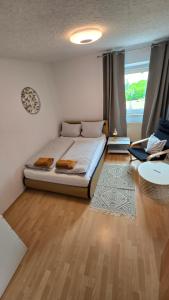 a bedroom with a bed and a living room at Ferienwohnung Regina in Undenheim