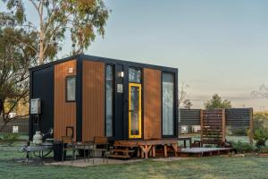 a tiny house with a table and benches at D&L Cottage by Tiny Away in Kudla