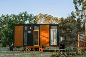 a tiny house with a table and benches at D&L Cottage by Tiny Away in Kudla