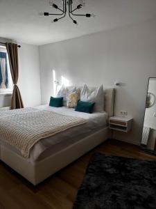 a bedroom with a large white bed with blue pillows at Haus Wildblick in Fladnitz an der Teichalm