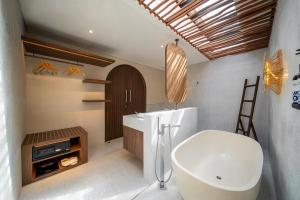 a bathroom with a white tub and a sink at Solaris Villa Bali in Kuta +18 photos
