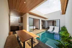 an indoor pool in a house with a table and chairs at Solaris Villa Bali in Kuta