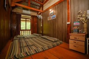 a bedroom with a bed and a dresser in a room at Mây farmstay in Ðà Bắc +68 photos
