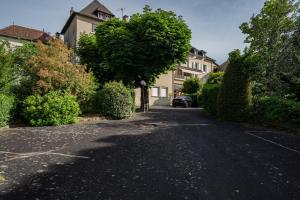 an empty street with a house and a tree at Beauséjour in Calvinet +11 photos