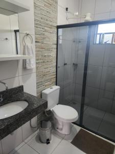 a bathroom with a toilet and a glass shower at Casa Mirante da Lua in Cavalcante