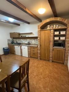 a kitchen with wooden cabinets and a table and chairs at penzionMoravia in Moravská Nová Ves