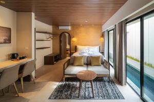 a bedroom with a bed and a desk and a table at Solaris Villa Bali in Kuta