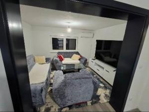a living room with a couch and a tv at Apartman Florida ranč in Doboj