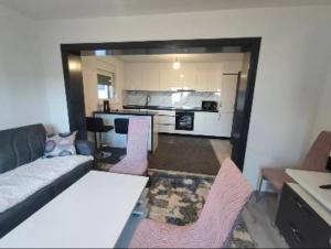 a living room with a couch and chairs and a kitchen at Apartman Florida ranč in Doboj