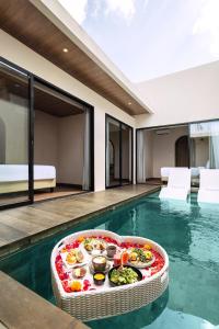 a swimming pool with a tray of food in a house at Solaris Villa Bali in Kuta
