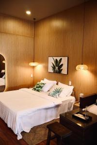 a bedroom with a large white bed and a table at Marina Bến Du Thuyền in Ấp Long Ðại
