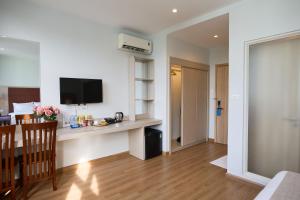 a living room with a table and a television in a room at Viona Beach Hotel - Marina Phu Quoc in Phú Quốc
