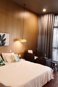 a bedroom with a large white bed and a window at Marina Bến Du Thuyền in Ấp Long Ðại