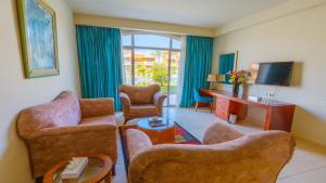 a living room with two chairs and a tv at Parrotel Lagoon Waterpark Resort in Sharm El Sheikh