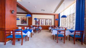 a dining room with blue tables and blue chairs at Parrotel Lagoon Waterpark Resort in Sharm El Sheikh