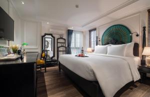 a bedroom with a large white bed and a desk at Sapa Boutique Hotel & Spa in Sapa