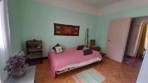 a bedroom with a pink bed in a room at Chez Valérie côté Sud in Saint-Jean-du-Gard +11 photos