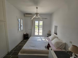 a white room with a bed and a window at Villa Thalassa - Vathy in Sifnos