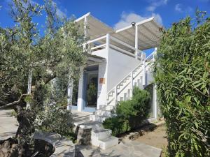 a white house with trees in front of it at Villa Thalassa - Vathy in Sifnos